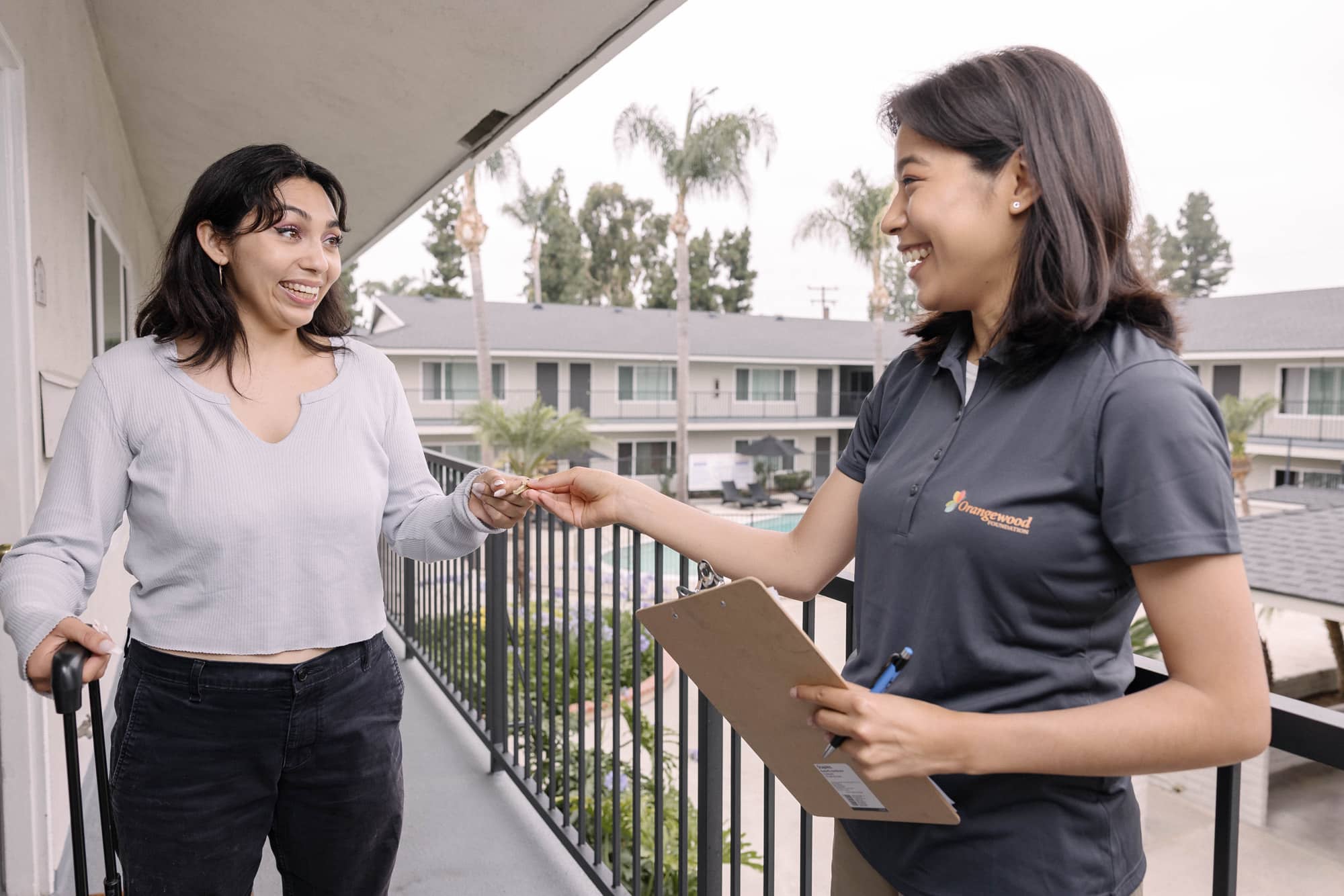 Staff handing key to young woman
