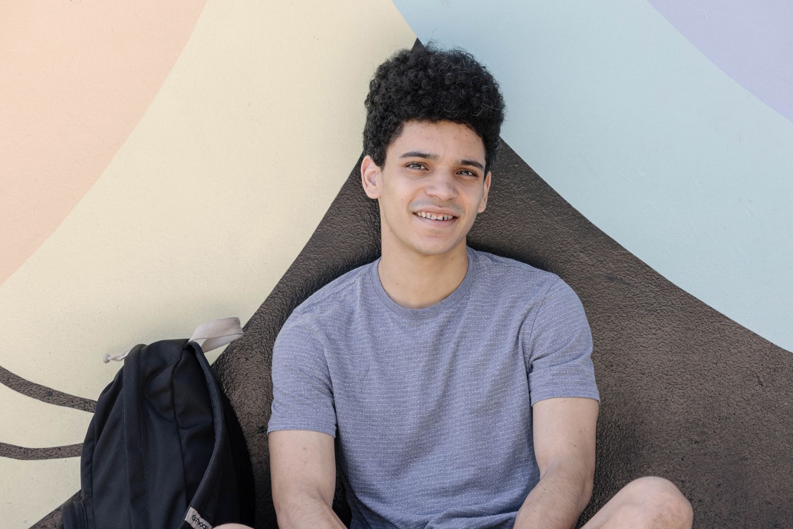 Young man sitting front of the wall