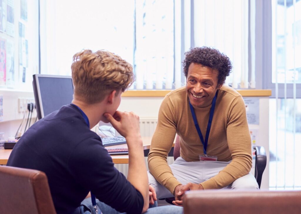 Male college student meeting with campus counselor