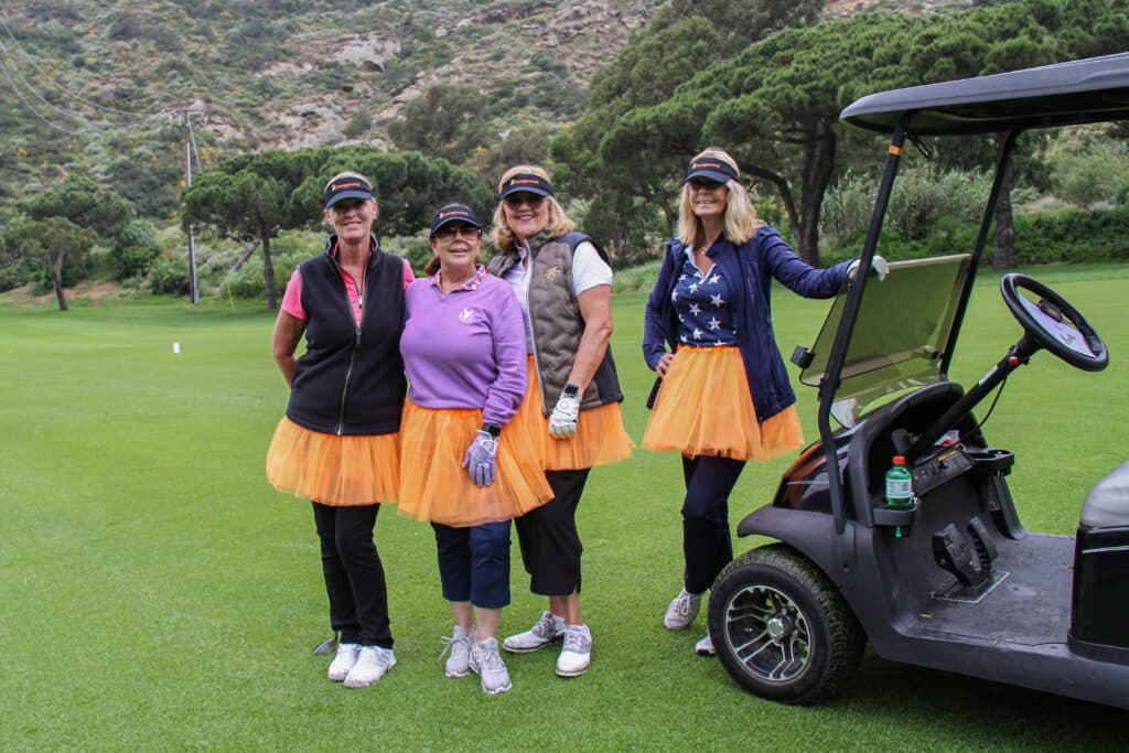 Women in orange tutus celebrating 44WFO Golf Event